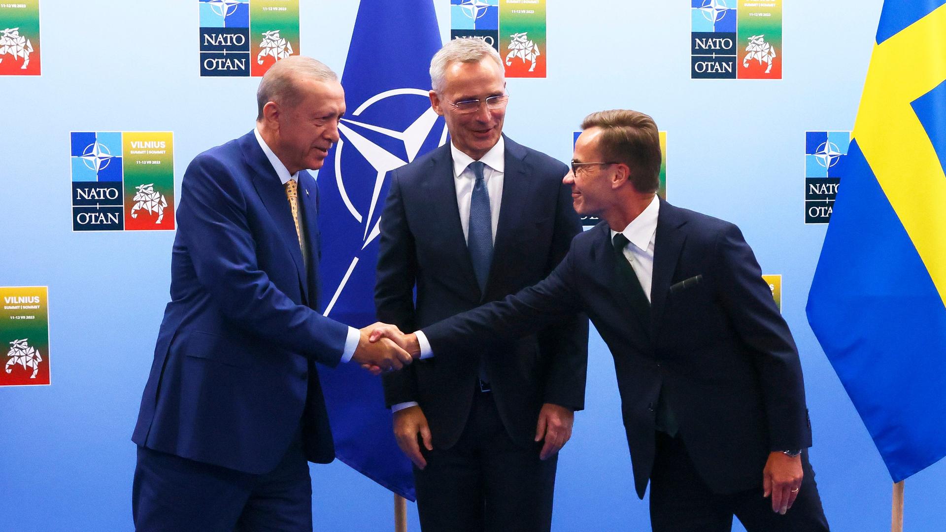 Der türkische Präsident Erdogan (links) schüttelt die Hand von Schwedens Premierminister Kristersson. In der Mitte steht NATO-Generalsekretär Erdogan.