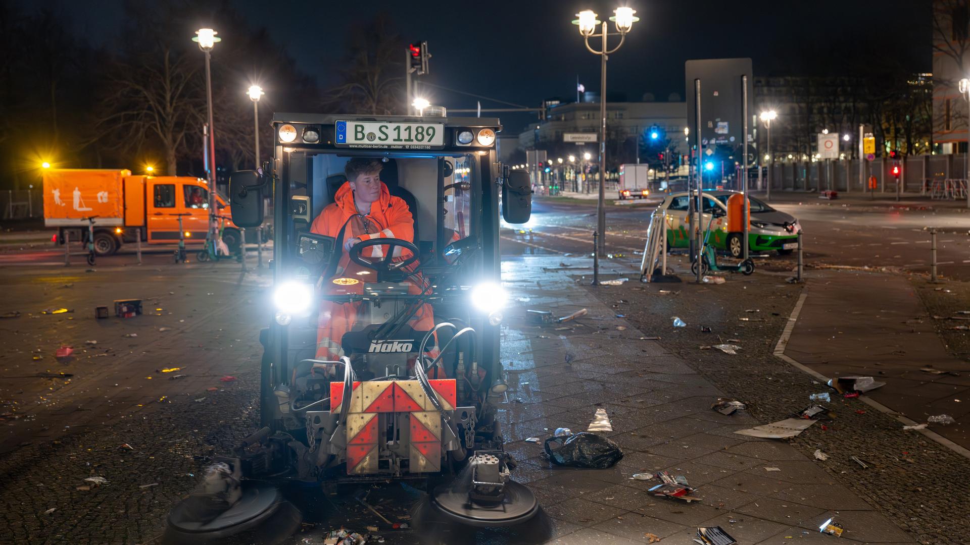 Eine Mitarbeiterin der Berliner Stadtreinigung (BSR) räumt mit der Kehrmaschine den Müll der Silvesternacht vom Fußweg der Ebertstraße in Berlin.
