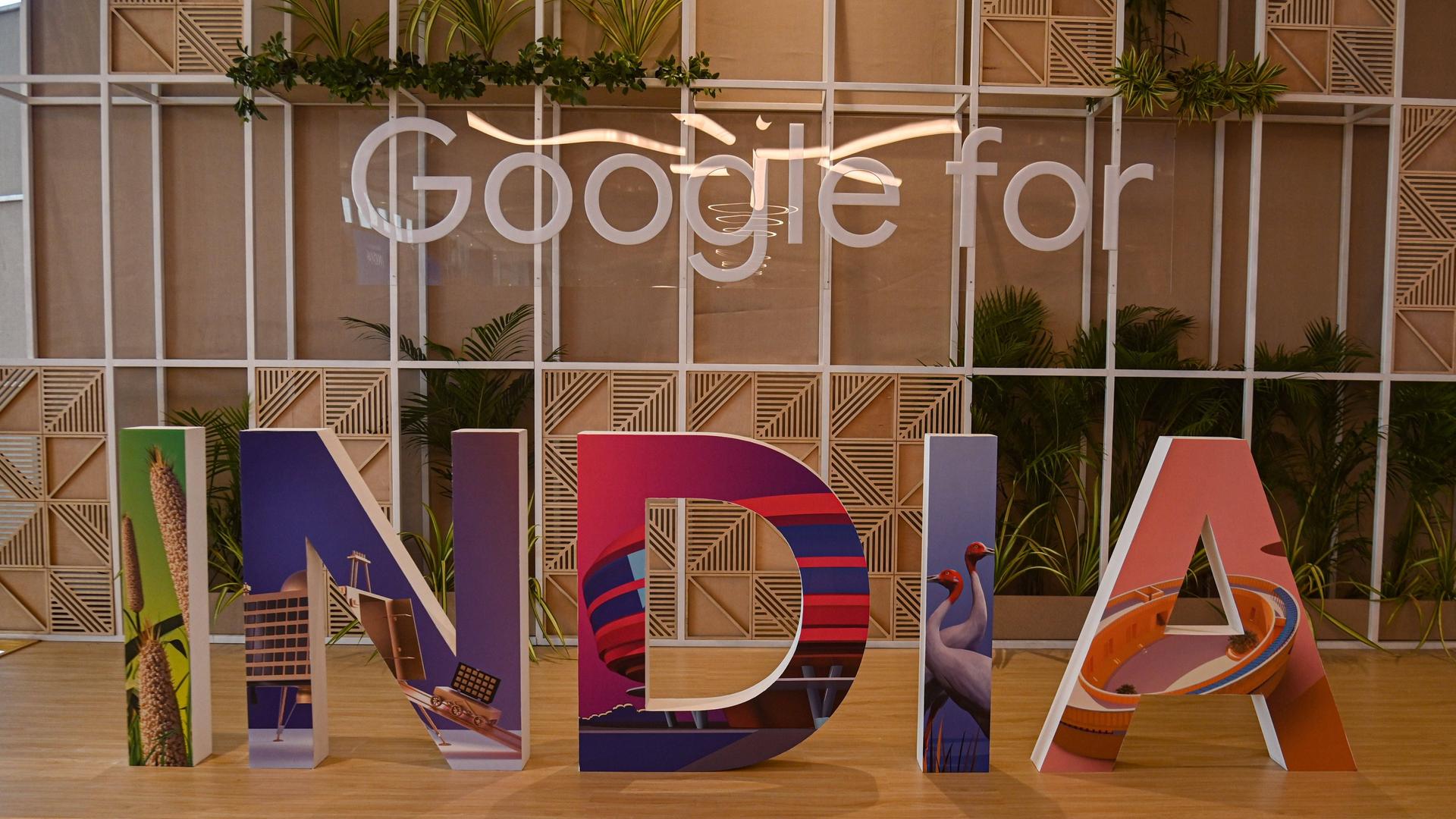 Ein weißer Schriftzug "Google for" an einer Glaswand und große, bunte Buchstaben "India" auf dem Boden.