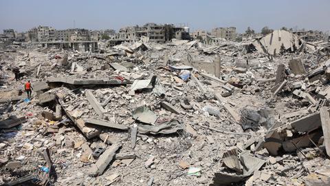 Ein Trümmerfeld in Gaza-Stadt, im Hintergrund sind Reste schwer beschädigter Häuser zu sehen.