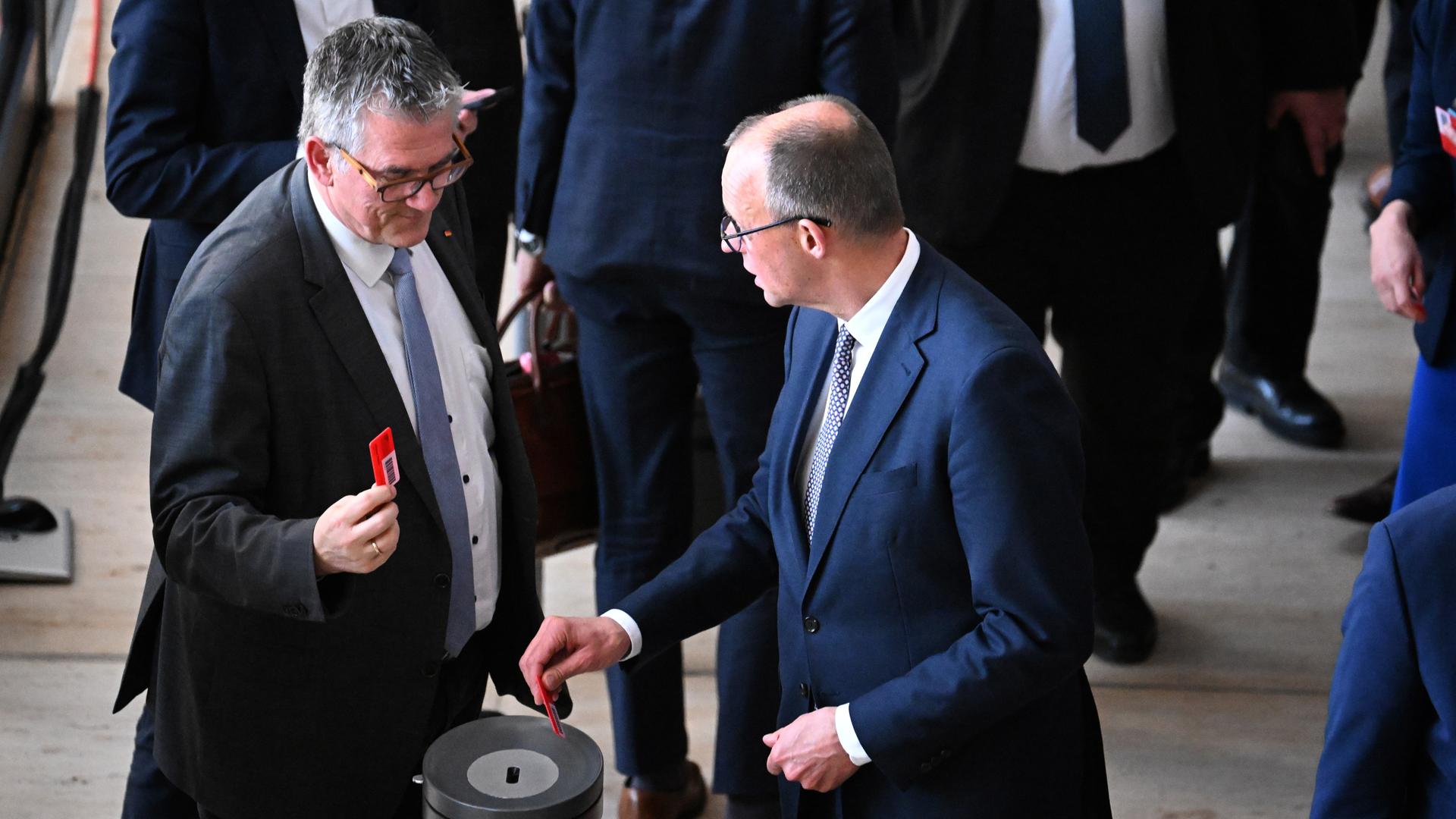 Friedrich Merz (r), CDU/CSU Fraktionsvorsitzender und CDU Bundesvorsitzender, stimmt ab über den ersten Entschließungsantrag in der 214. Plenarsitzung der 20. Legislaturperiode im Deutschen Bundestag. 
