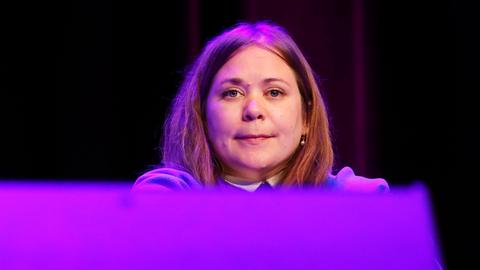 Eine junge Frau mit schulterlangen rötlich-hellbraunen Haaren sitzt auf einem Podium. Es ist die österreichische Autorin Stefanie Sargnagel.