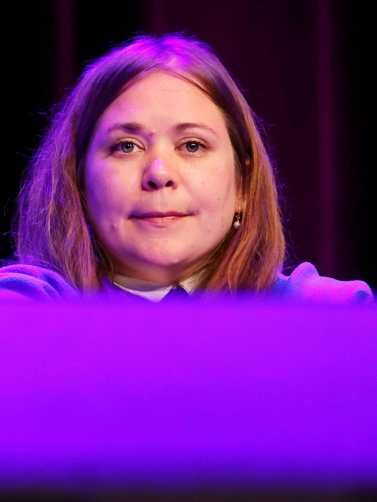 Eine junge Frau mit schulterlangen rötlich-hellbraunen Haaren sitzt auf einem Podium. Es ist die österreichische Autorin Stefanie Sargnagel.