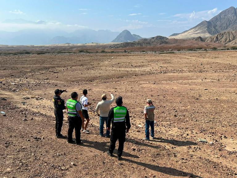 Dieses am 15. Juni 2026 vom peruanischen Kulturministerium der Region La Libertad veröffentlichte Bild zeigt Polizeibeamte und Experten in der Nähe der mehr als 1.000 Jahre alten vorspanischen Geoglyphe „Dreifachspirale“.