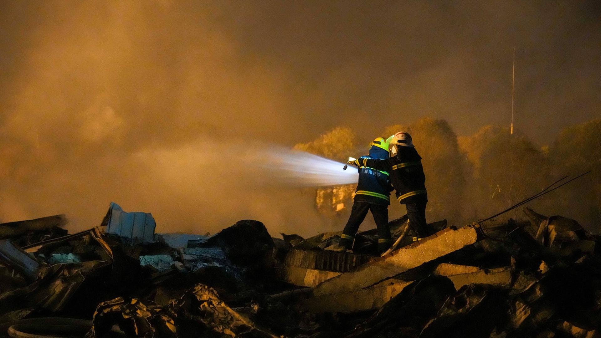 Rettungskräfte sind nach einer Explosion in einer Feuerwerksfabrik in der Gemeinde Guandu (Liuyang, Provinz Hunan in Zentralchina) mit Feuerlöschern im Einsatz.