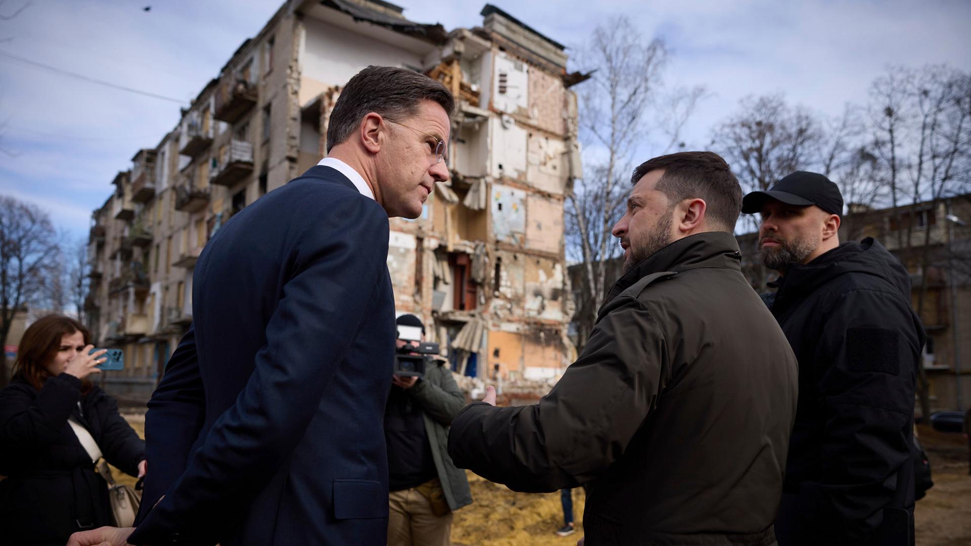 Wolodymyr Selenskyj und Mark Rutte besichtigen durch russische Raketenangriffe beschädigte Wohnhäuserin Charkiw.