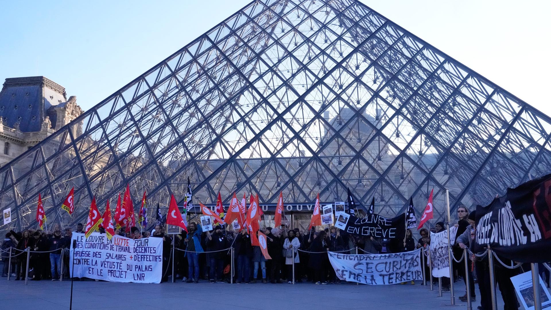 Angestellte stehen vor der Glaspyramide im Louvre, nachdem sie für einen Streik gestimmt haben. 