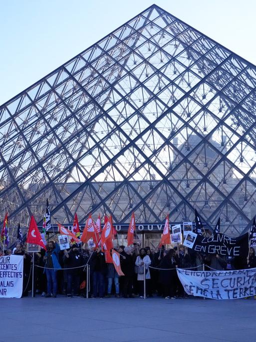 Angestellte stehen vor der Glaspyramide im Louvre, nachdem sie für einen Streik gestimmt haben. 