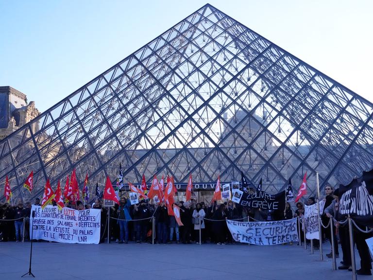 Angestellte stehen vor der Glaspyramide im Louvre, nachdem sie für einen Streik gestimmt haben. 