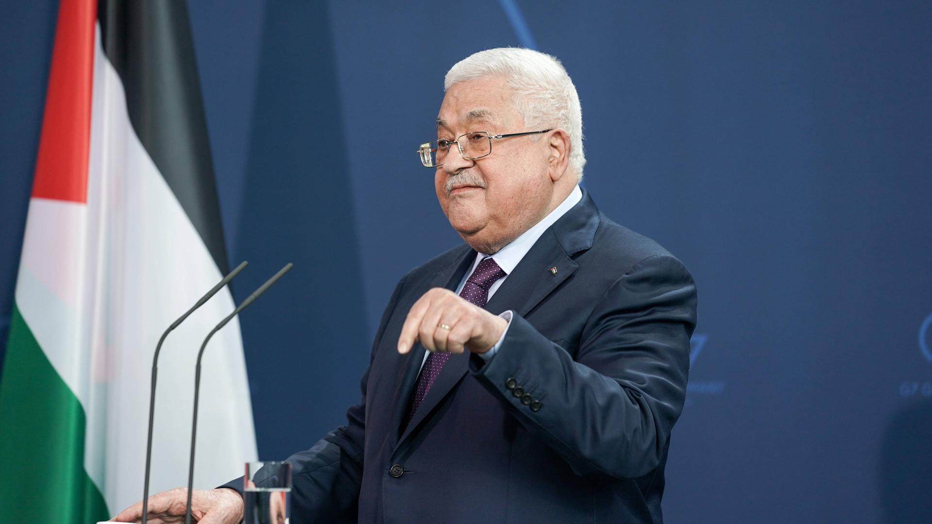Der Präsident der Palästinensischen Autonomiebehörde Mahmoud Abbas steht vor einem Mikrofon, in Hintergrund die palästinensische Flagge.