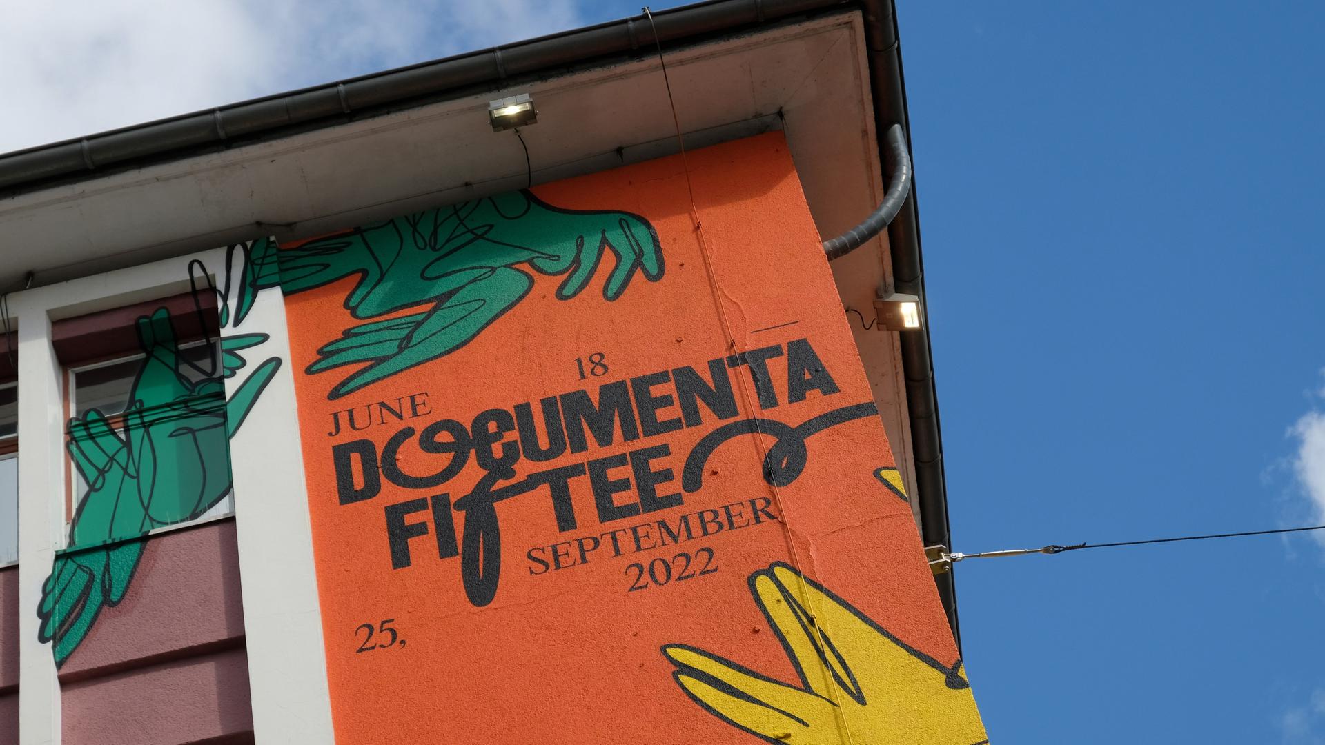 Der Schriftzug "documenta fifteen" und das Logo vom indonesischen Kuratorenkollektiv Ruangrupa prangt an einer Fassade