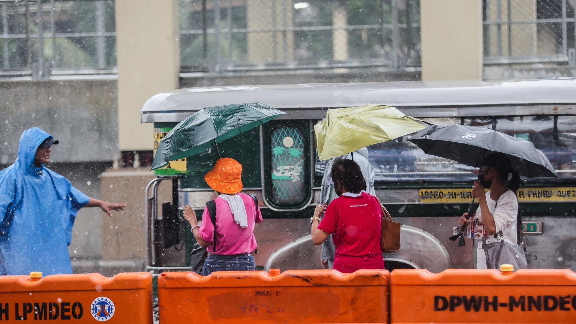 Philippinen, Quezon City: Menschen benutzen Regenschirme, um sich vor dem starken Regen zu schützen, den der Taifun "Gaemi" mit sich brachte. Philippinen, Quezon City: Menschen benutzen Regenschirme, um sich vor dem starken Regen zu schützen, den der Taifun "Gaemi" mit sich brachte.