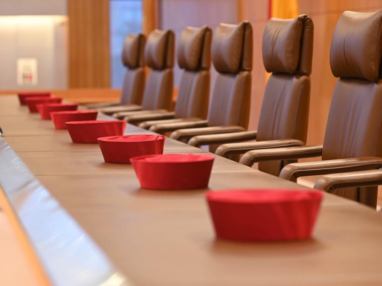 Auf der Richterbank im Sitzungssaal im Bundesverfassungsgericht liegen Barette der Bundesverfassungsrichter des ersten Senats.
