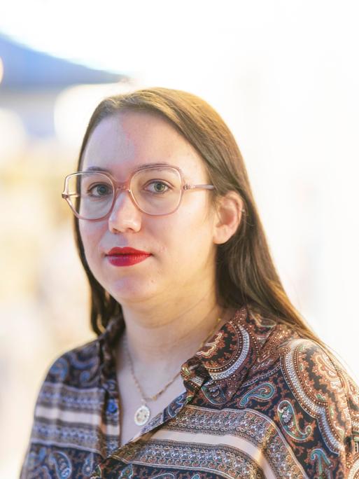 Ronya Othmann, Schriftstellerin und Journalistin steht im Schauspiel Frankfurt und blickt in die Kamera
