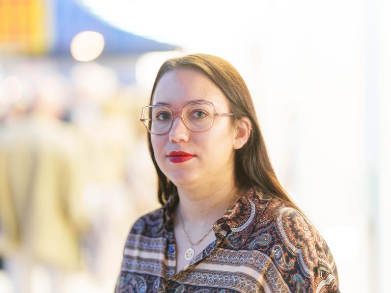 Ronya Othmann, Schriftstellerin und Journalistin steht im Schauspiel Frankfurt und blickt in die Kamera