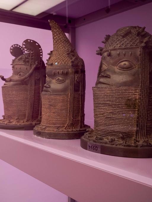 Abgüsse der Benin-Bronzen stehen in einem pinken Schaukasten in einem Museum in Den Haag