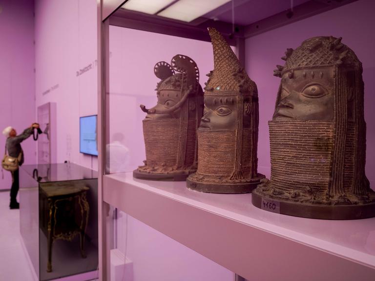 Abgüsse der Benin-Bronzen stehen in einem pinken Schaukasten in einem Museum in Den Haag