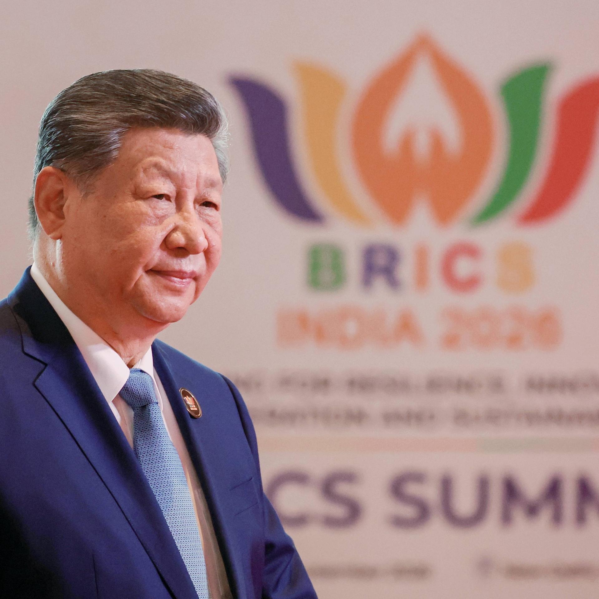 Chinas Staatschef Xi steht vor dem Logo des BRICS-Gipfels in Neu-Delhi.
