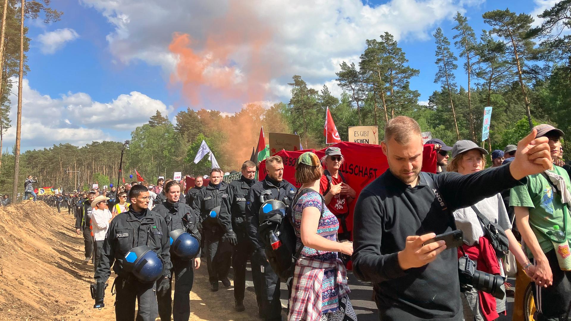 Einsatzkräfte der Polizei begleiten den Demonstrationszug zum Tesla-Werk.