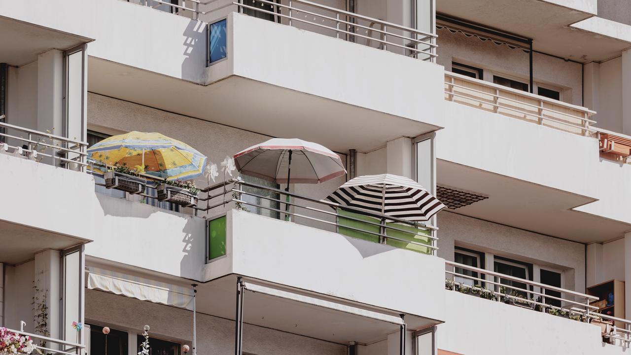 Sonnenschirme auf dem Balkon eines Plattenbaus, aufgenommen 2024 in Berlin
