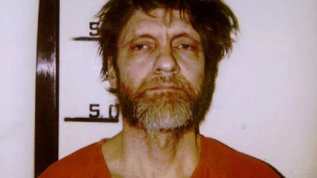 Das Polizeifoto von Ted Kaczynski, dem sogenannten "Unabomber". Er trägt ein oranges Hemd und macht einen derangierten Eindruck.