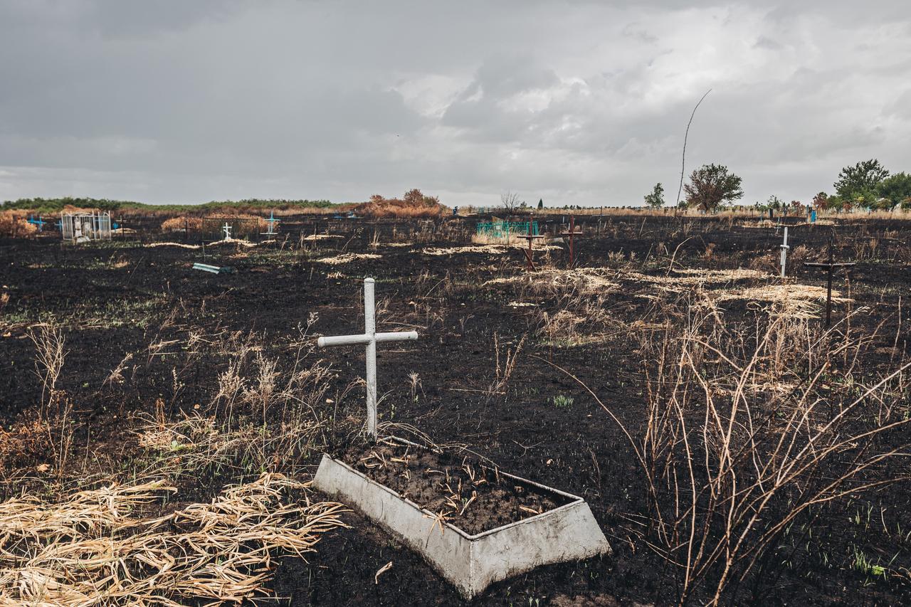 Ein Grab mit einem Kreuz im Kampfgebiet im Osten der Ukraine 