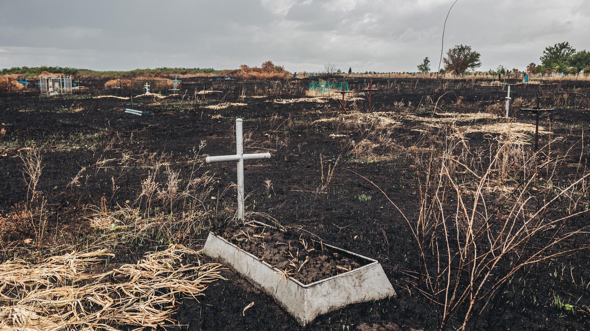 Ein Grab mit einem Kreuz im Kampfgebiet im Osten der Ukraine