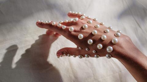 Eine mit Perlen beklebte Hand.