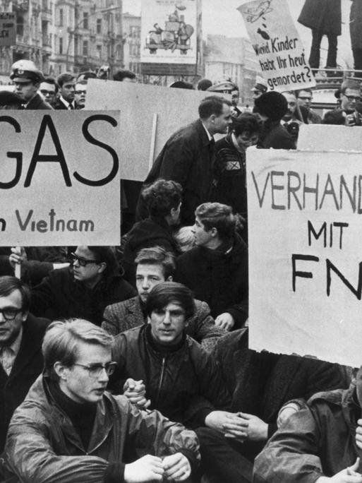 Ein Schwarz-Weiß-Foto mit Demonstierenden; auf ihren Transparenten steht "Kein Gas - auch in Vietnam" und "Verhandlungen mit der FNL!" Ein Schwarz-Weiß-Foto mit Demonstierenden; auf ihren Transparenten steht "Kein Gas - auch in Vietnam" und "Verhandlungen mit der FNL!"
