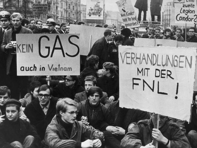 Ein Schwarz-Weiß-Foto mit Demonstierenden; auf ihren Transparenten steht "Kein Gas - auch in Vietnam" und "Verhandlungen mit der FNL!" Ein Schwarz-Weiß-Foto mit Demonstierenden; auf ihren Transparenten steht "Kein Gas - auch in Vietnam" und "Verhandlungen mit der FNL!"