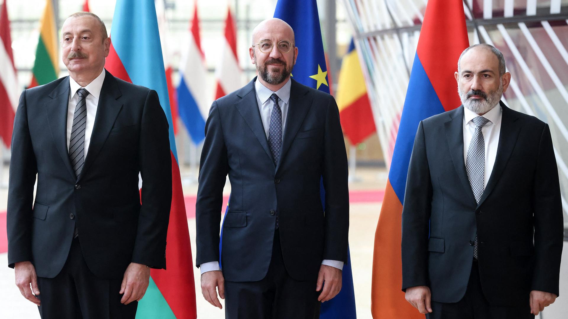 Aserbaidschans Präsident Ilham Alijew (l.), EU-Ratspräsident Charles Michel (Mitte) und Armeniens Ministerpräsident Nikol Paschinjan (r.) stehen nebeneinander, hinter ihnen die Flaggen ihrer Länder und der Europäischen Union. Aserbaidschans Präsident Ilham Alijew (l.), EU-Ratspräsident Charles Michel (Mitte) und Armeniens Ministerpräsident Nikol Paschinjan (r.) stehen nebeneinander, hinter ihnen die Flaggen ihrer Länder und der Europäischen Union.