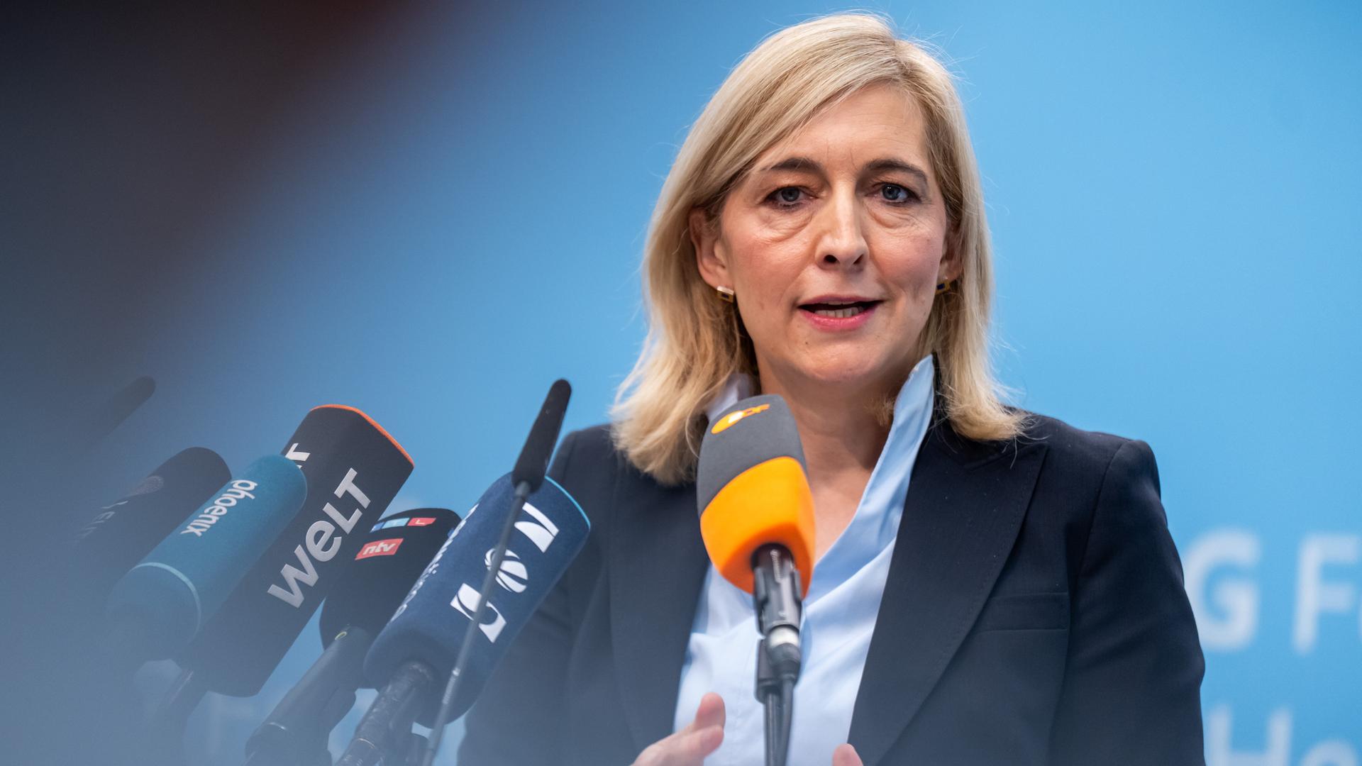 Nina Warken spricht bei einer Pressekonferenz zum geplanten Sparpaket gegen höhere Kassenbeiträge vor einem blauen Hintergrund in mehrer Mikrofone.
Nina Warken spricht bei einer Pressekonferenz zum geplanten Sparpaket gegen höhere Kassenbeiträge vor einem blauen Hintergrund in mehrer Mikrofone.