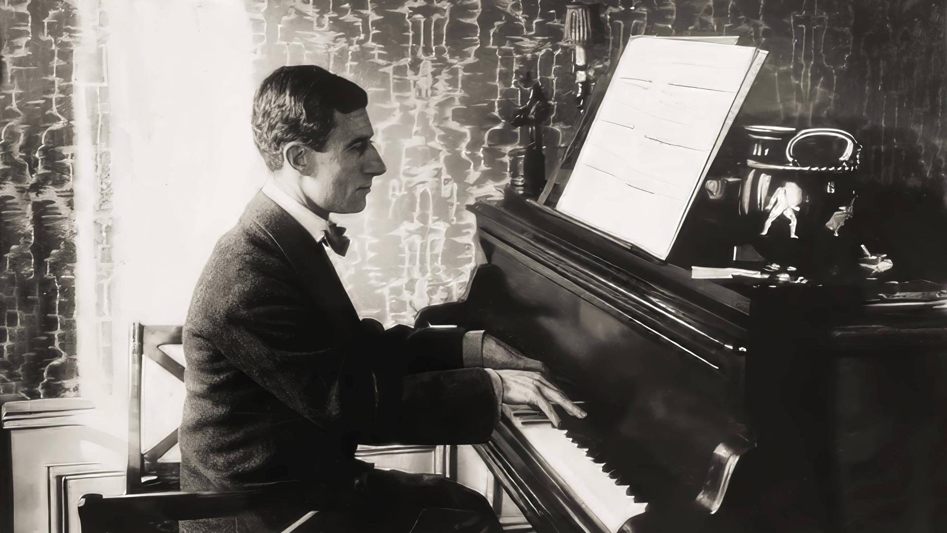 Maurice Ravel sitzt in seinem Wohnzimmer an seinem Flügel und spielt gerade aus aufgeschlagenen Noten. 