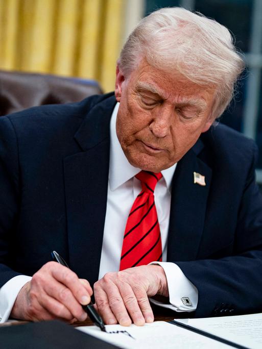 US-Präsident Donald Trump unterzeichnet das Zoll-Dekret im Oval Office mit einem dicken schwarzen Stift, 10. Januar 2025.