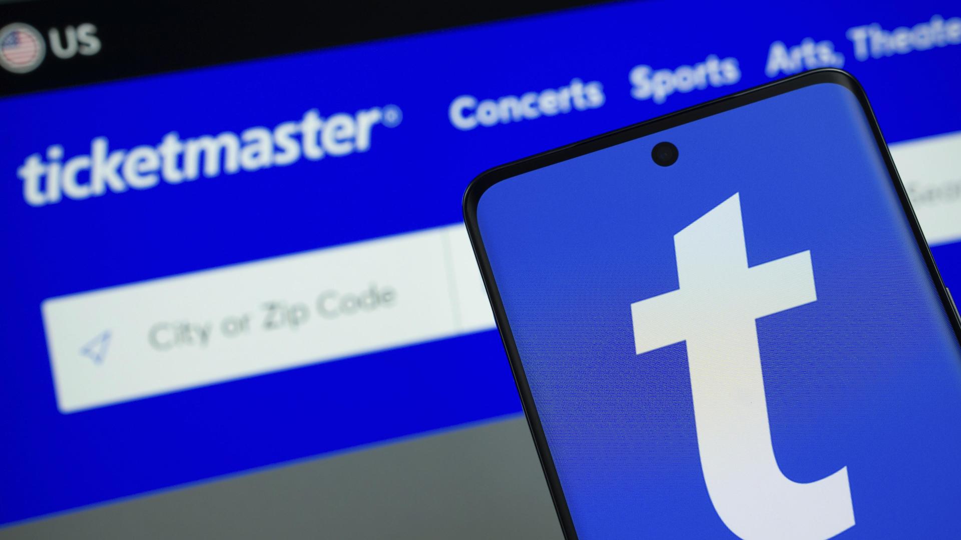 Das Logo von Ticketmaster wird auf einem Smartphone Bildschirm angezeigt, und die Website Ticketmaster ist auf einem Computerbildschirm im Hintergrund zu sehen. (Quelle: picture allliance) 