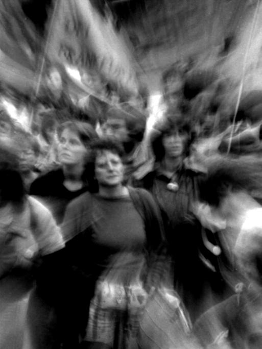 Schwarz-Weiß-Foto einer Demo, ganz verschwommen zu sehen