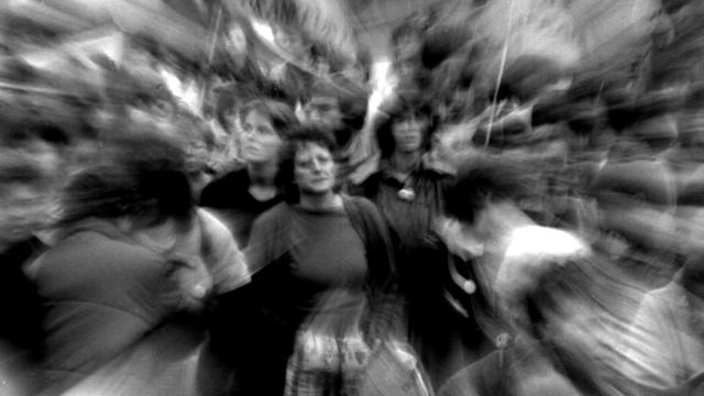 Schwarz-Weiß-Foto einer Demo, ganz verschwommen zu sehen