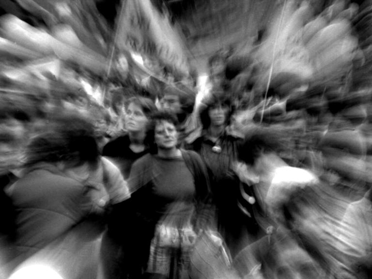 Schwarz-Weiß-Foto einer Demo, ganz verschwommen zu sehen