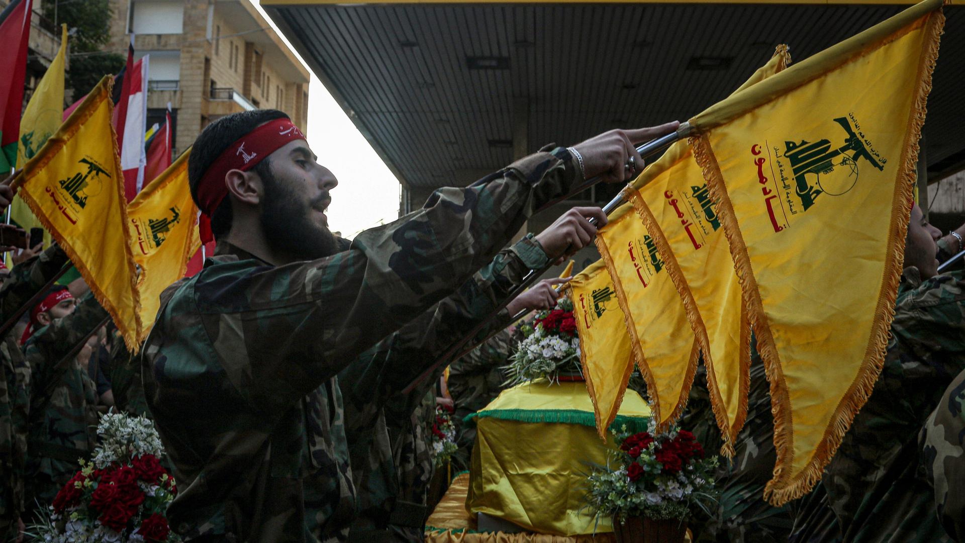 Pro-iranische Hisbollah-Anhänger halten Flaggen mit Symbol ihrer Organisation hoch
