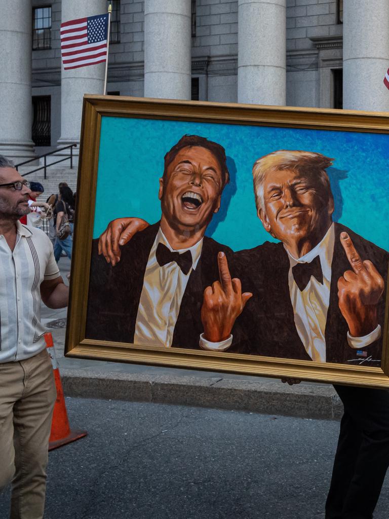 Inmitten von Demonstranten, die am Foley Square in New York gegen die Politik von Donald Trump in Bezug auf Zölle, Arbeitnehmerrechte und Bürgerrechte protestieren, ist ein Gemälde oder Kunstwerk mit den Figuren von Elon Musk und Trump zu sehen. 

