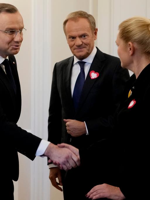 Polens Präsident Andrzej Duda (links) schüttelt der damaligen Oppositionspolitikerin Barbara Nowacka die Hand, während der damalige Oppositionsführer Donald Tusk (Mitte) am Dienstag, den 24. Oktober 2023, im Präsidentenpalast in Warschau, Polen, zuschaut. 