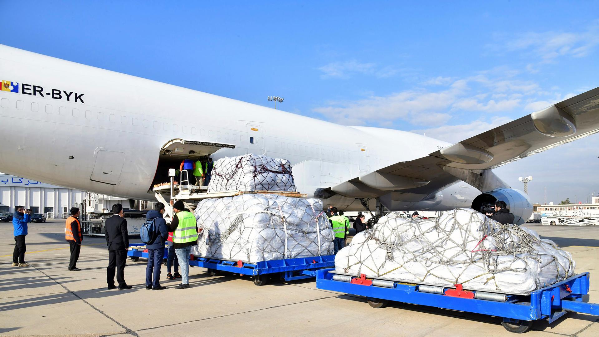 Arbeiter am Flughafen Damaskus entladen eine Maschine mit Hilfsgüters, die nach dem verheerenden Erdbeben von China nach Syrien geschickt wurden.