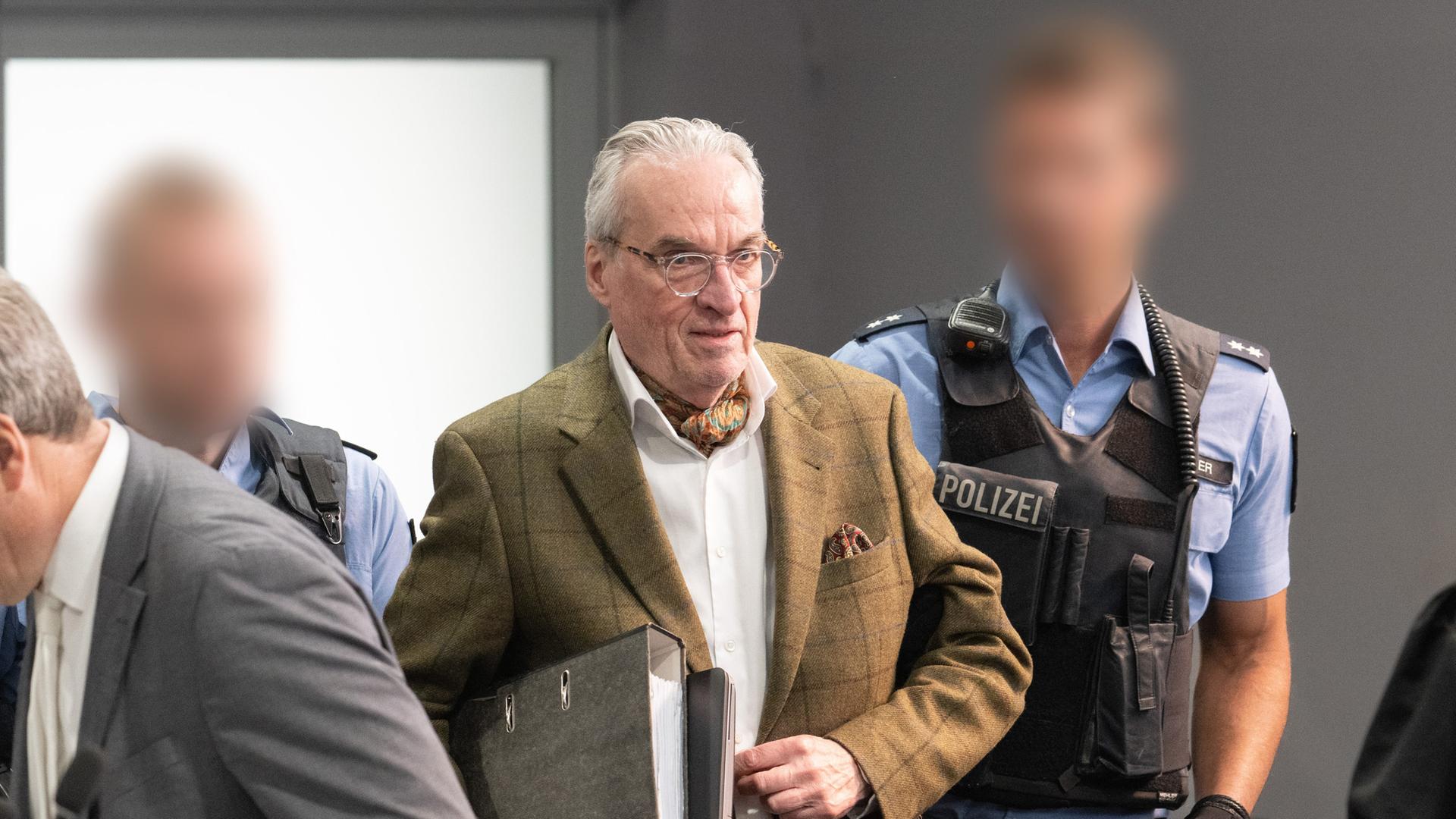 Der Hauptangeklagte Heinrich der XIII. Prinz Reuß (M) kommt von Polizisten gebracht in den Verhandlungssaal im Oberlandesgericht Frankfurt, Außenstelle im Stadtteil Sossenheim. Der Hauptangeklagte Heinrich der XIII. Prinz Reuß (M) kommt von Polizisten gebracht in den Verhandlungssaal im Oberlandesgericht Frankfurt, Außenstelle im Stadtteil Sossenheim.