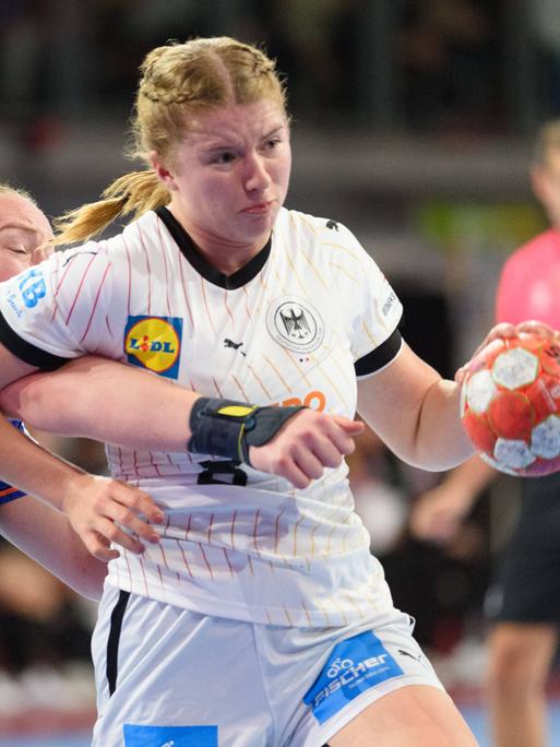 Nina Engel hat den Ball. Eine Gegenspielerin hängt an ihr.