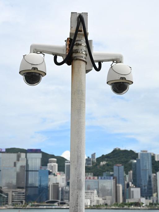 Eine Überwachungskamera hängt im Victoria Harbour in Hongkong, im Hintergrund ist die Skyline der Stadt zu sehen.