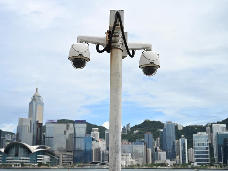 Eine Überwachungskamera hängt im Victoria Harbour in Hongkong, im Hintergrund ist die Skyline der Stadt zu sehen.