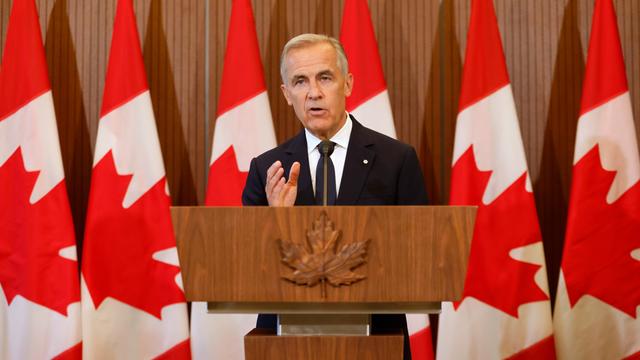 Kanadas Premierminister Mark Carney spricht an einem Rednerpult und vor kanadischen Flaggen auf einer Pressekonferenz.