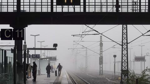 Reisende warten im Nebel auf dem Leipziger Hauptbahnhof.