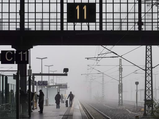 Reisende warten im Nebel auf dem Leipziger Hauptbahnhof.
