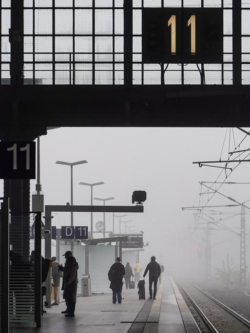 Reisende warten im Nebel auf dem Leipziger Hauptbahnhof.